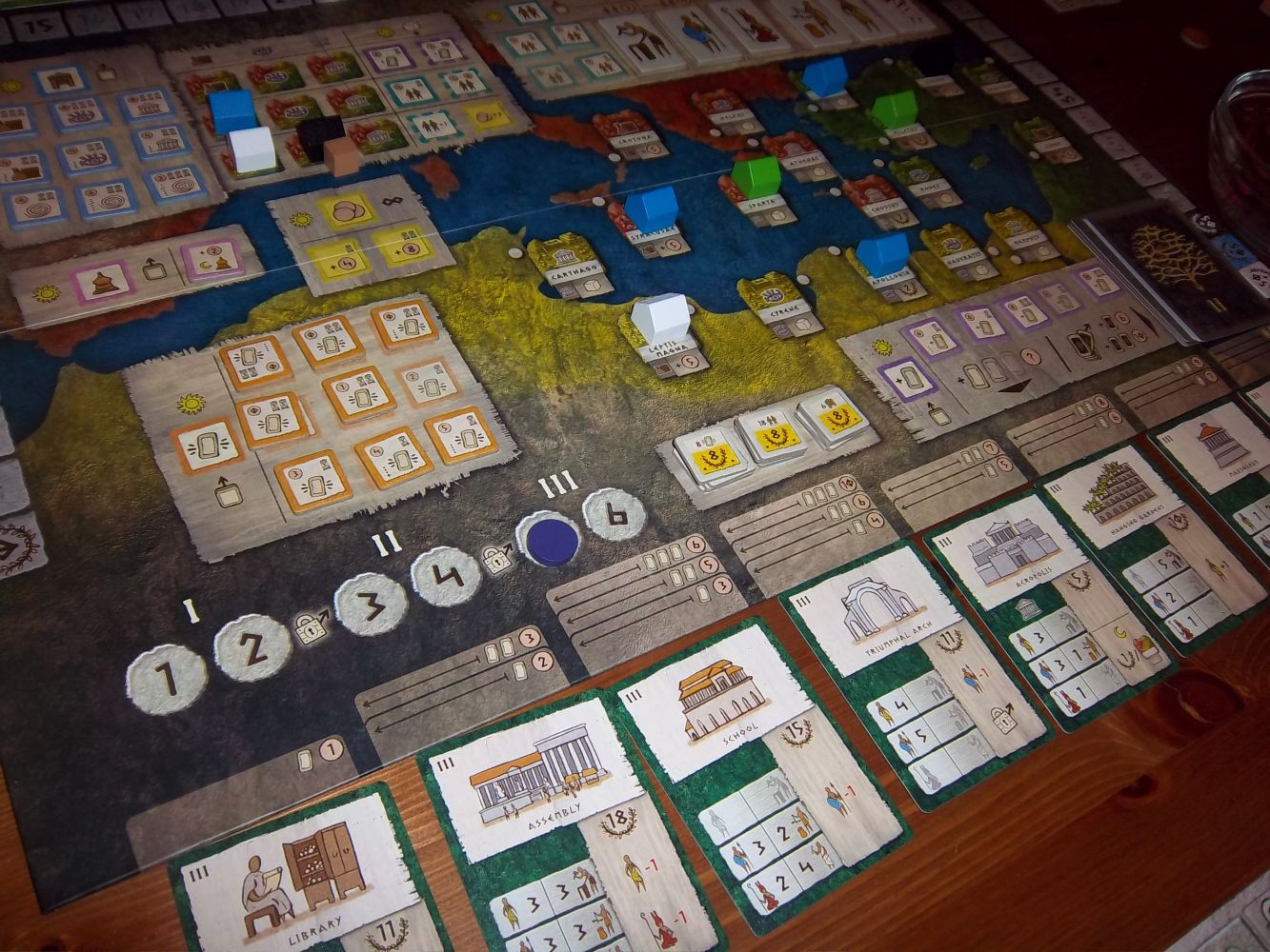 Une partie config 4 en cours de Gentes. Des tuiles actions, des pions cités,, des cartes de l'ère III