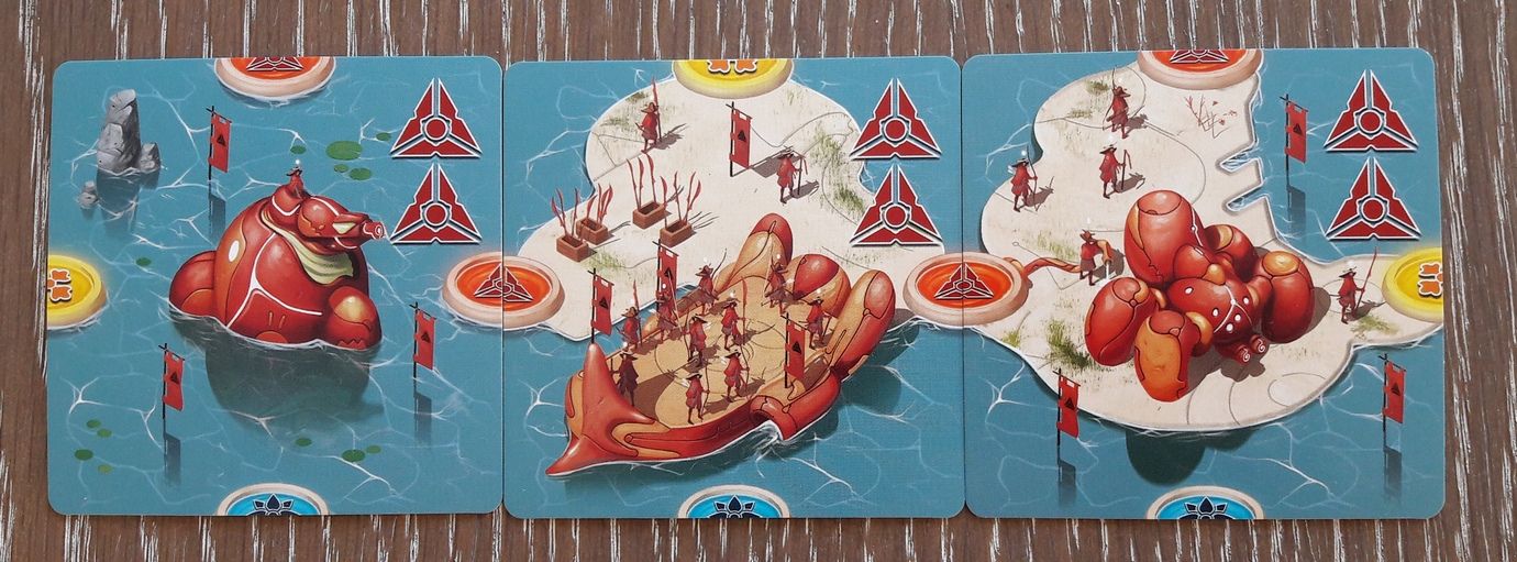 Les cartes îles.  3/5 : les bâtiments militaires. L'arsenal de Mû fait le grand écart entre le canon à énergie et la hallebarde.