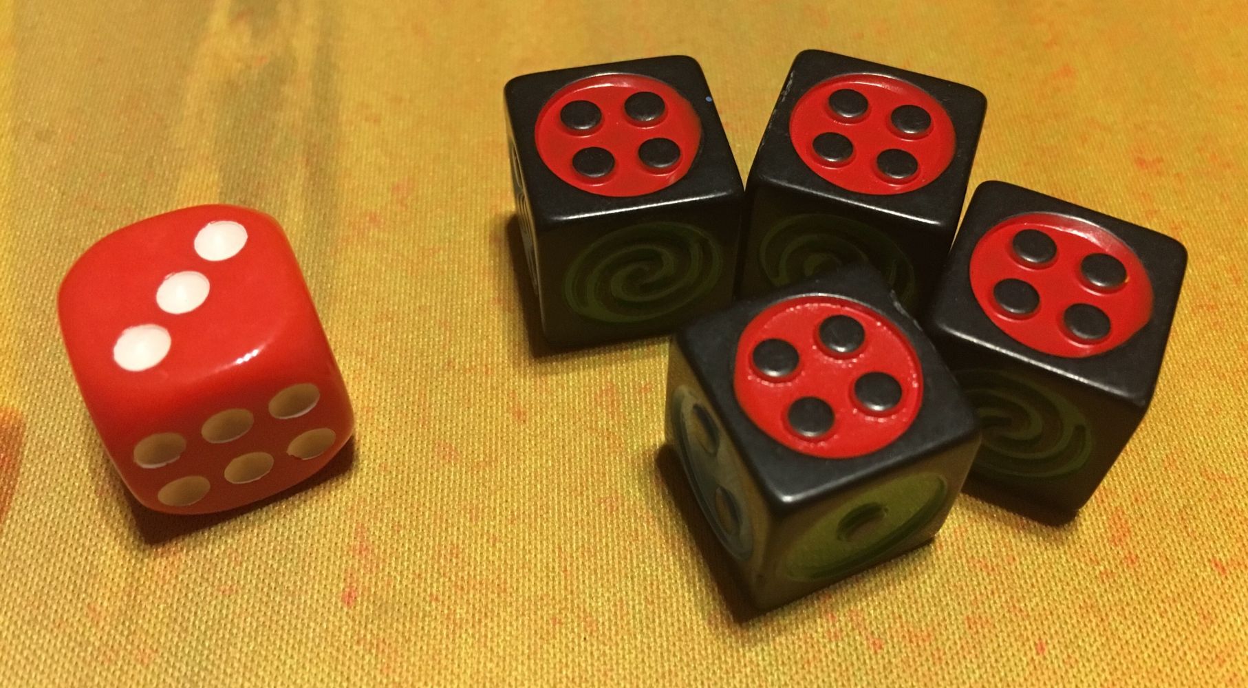 Le dé de combat et les dés Dicium sur leur face rouge