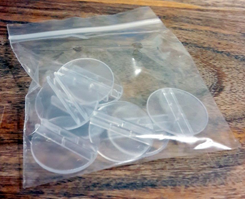 Les supports pour les pions joueurs dans leur sachet.