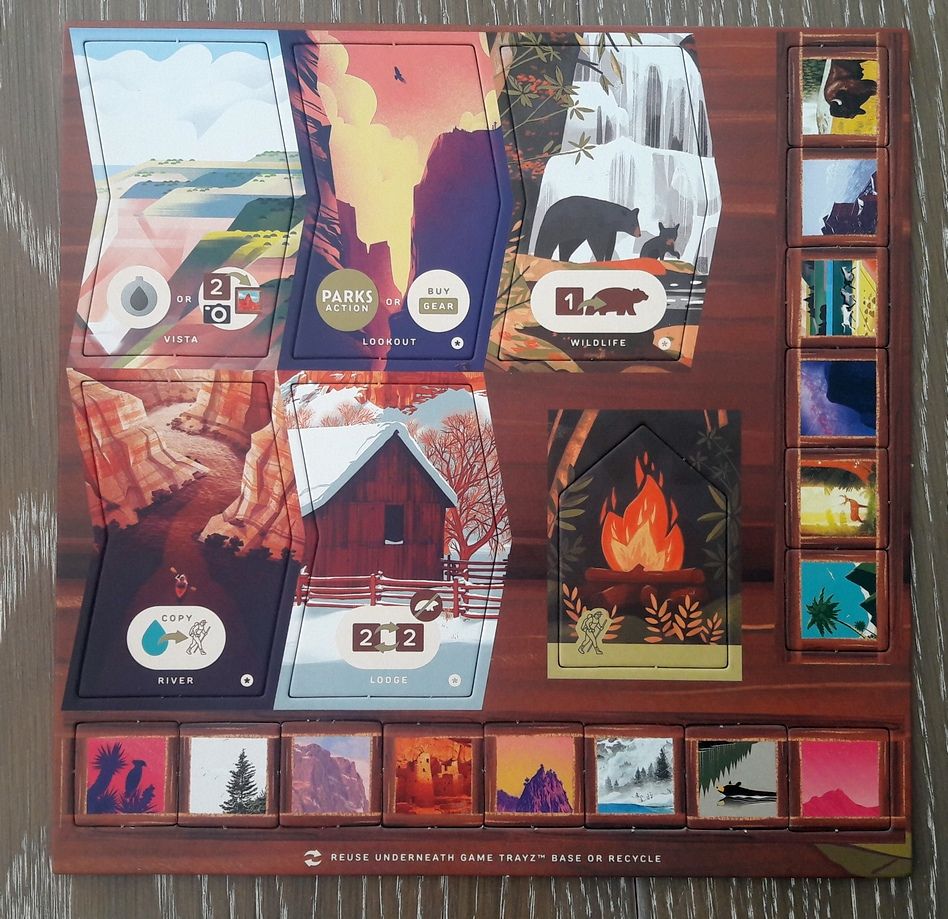 Planche n°2 : la tuile du point de vue (Vista : est l'emplacement qui permet de faire des photos) . Les tuiles spéciales (celles qui sont marquées d’une ‘*’) , le feu de camp du joueur vert et toujours des jetons photos … tous uniques.