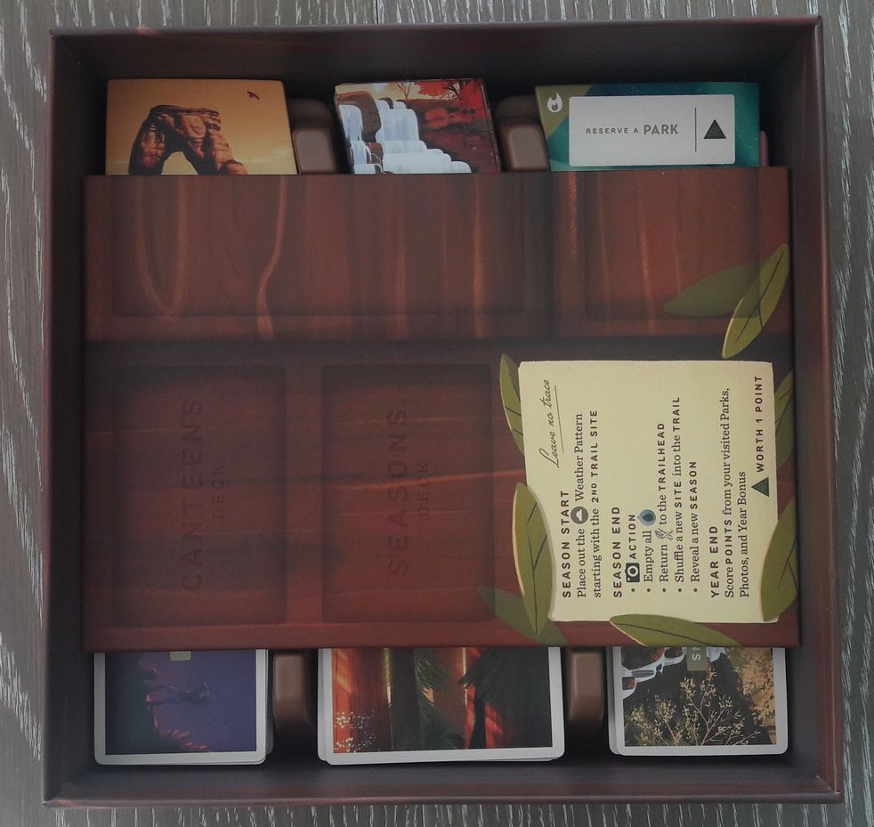 Le plateau vient bloquer les cartes les tuiles et les randonneurs, il ne reste plus qu'à placer les boite de jetons par dessus pour finir.  C’est parfait !