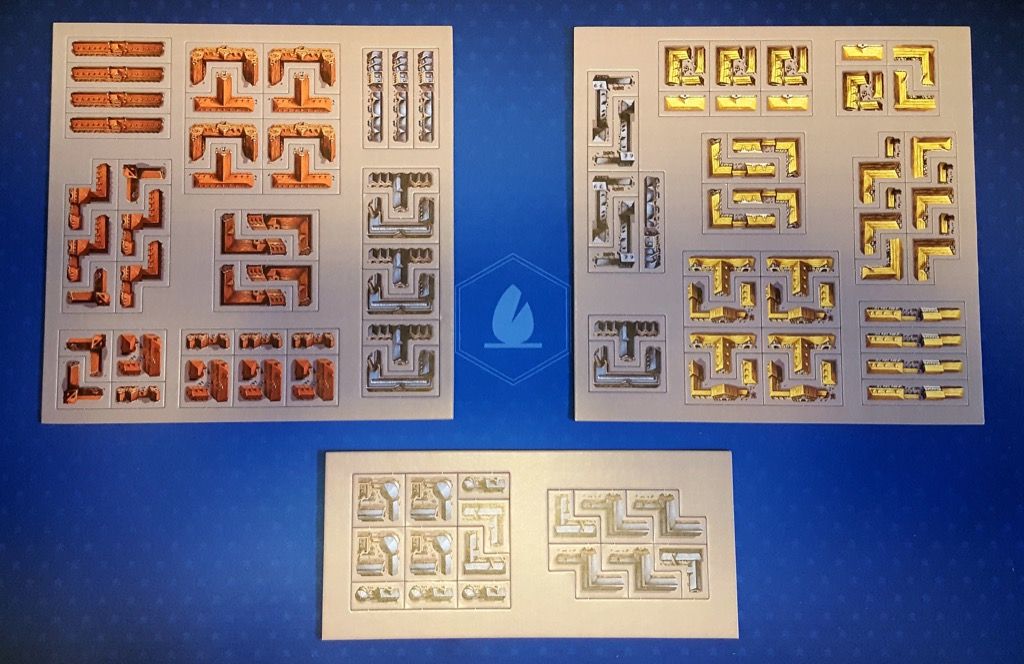 4 lots de tuiles contenant chacun huit bâtiments de trois couleurs différentes : rouge (administratif), bleu (industriel) et jaune (résidentiel).