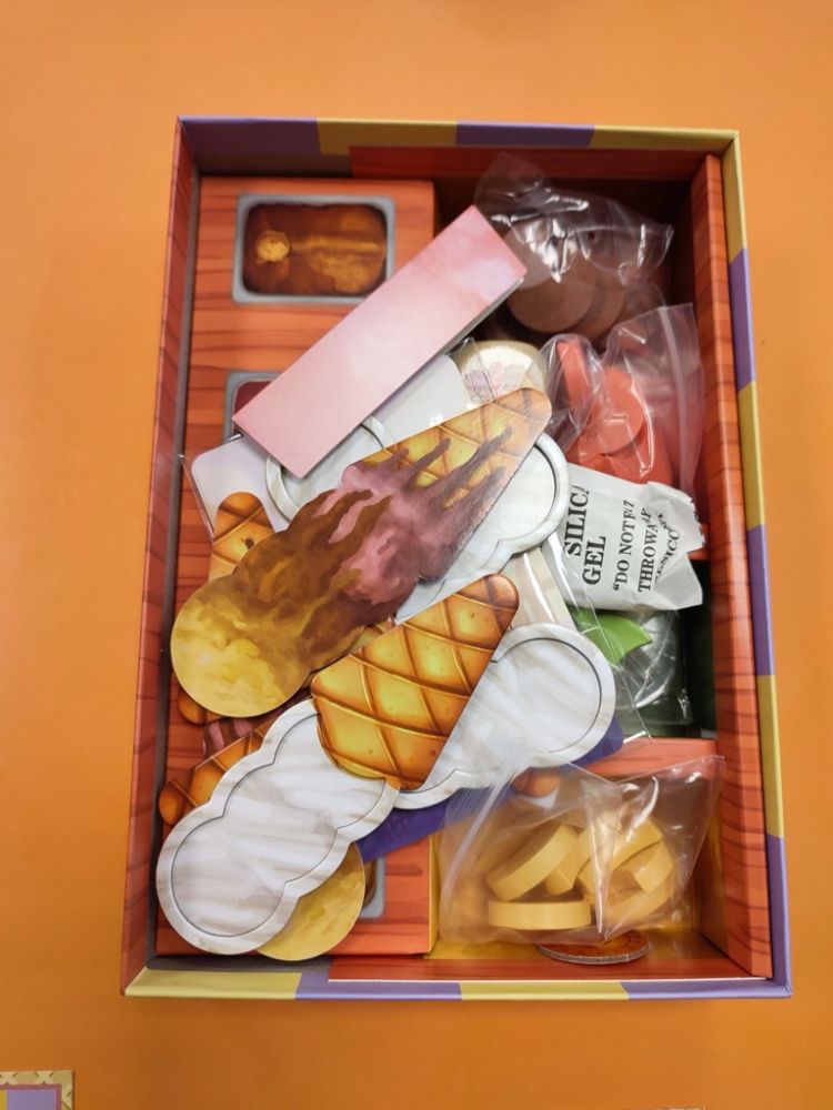 Le matériel à l'ouverture de la boite : des cornets de glaces recto/verso, des cartes Enfant, des boules de glaces en forme de demi lune, 1 soleil, 1 dé glacier et 1 pièce de monnaie.