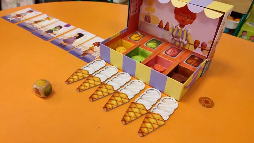 Le dé indique la face jaune, le petit joueur devra prendre une boule Vanille et la placer sur n'importe lequel des cornets.