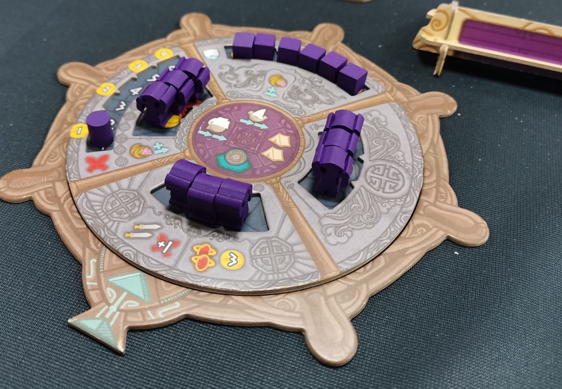 La roue d'action, avec les 4 possibilités.  Au fur et mesure que l'on débloque des meeples ou des ressources sur ce plateau on débloque des bonus.