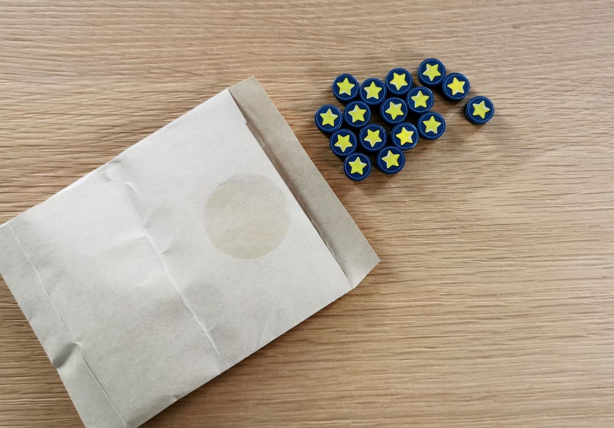 Les 16 pions médailles. Ils peuvent être conservés dans leur enveloppe d’origine. Le seul écart à l’utilisation du plastique est l'autocollant pour fermer cette enveloppe.