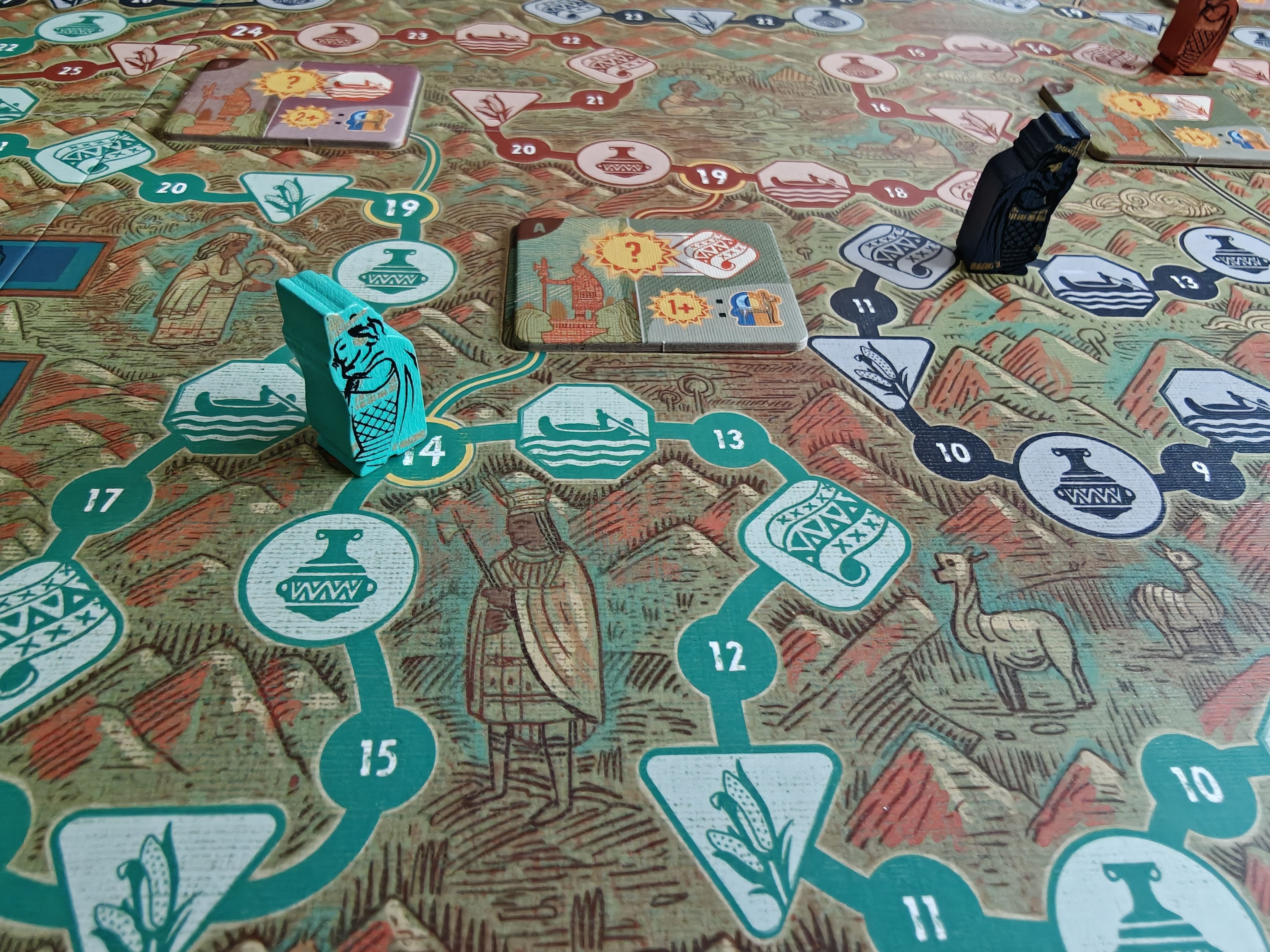 Ici, l'Ayar turquoise s'est arrêté sur la tuile Raymi avec une icône de tapisserie. A la fin du tour, un scoring de jour sur le tissage sera fait. Plus tard, si l'Ayar rouge passe par la case 19, un nouveau scoring sera effectué.