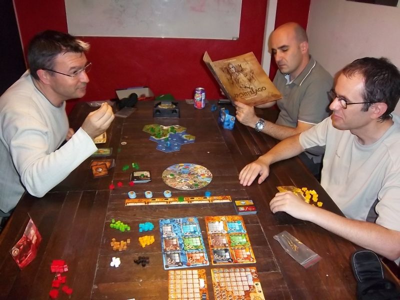 Monsieur Cormyr explique Archipelago à monsieur Florestan, pendant que monsieur Esperluette consulte les règles. 