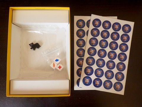 Un sachet avec 3 dés, un pion chat noir et 2 punchboards avec 56 jetons souris.