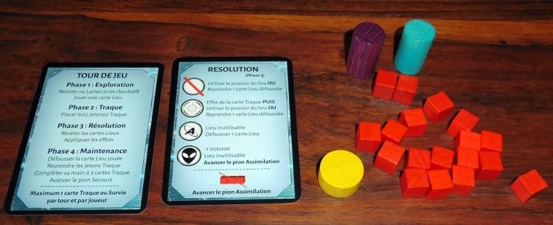 Les cubes de volonté, la balise jaune et les 2 pions d'arrivée des secours et d'assimilation et les aides de jeu pour référence de taille.