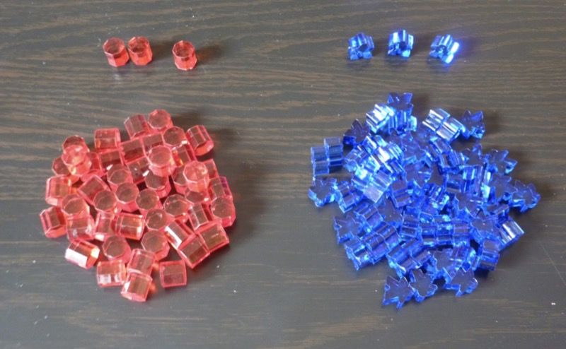 50 barils d'énergie (barils rouges) en plastique transparent et 65 habitants (meeples bleus) 