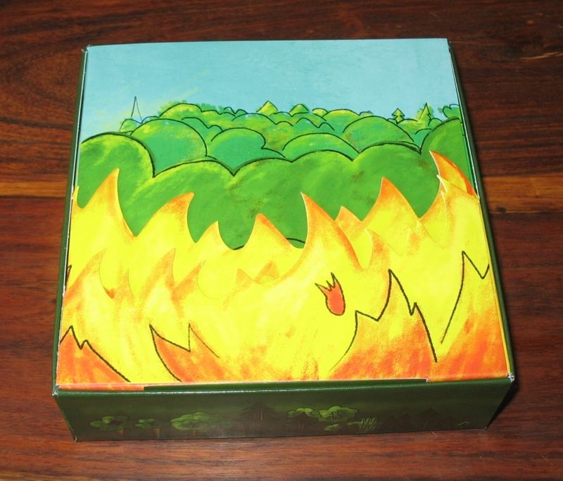 C'est mignon !!! Un joli jeu de cartons repliés qui forrme un feu devant la forêt avec en fond les règles...
