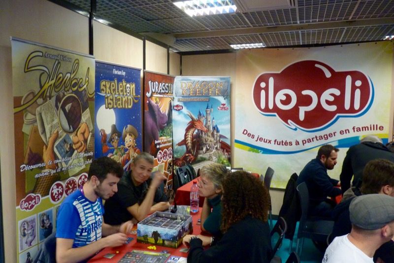 Après la partie je salue en face Arnaud Arbon le patron d'Ilopeli (de dos en train d'expliquer son jeu Dragon Keeper).