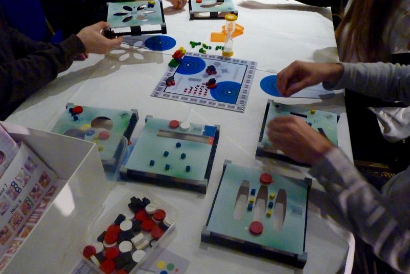 On est sur du matériel 3D. Il faut déplacer le plus rapidement les cubes sur les zones couleurs et pousser les pions rouges dans les trous.