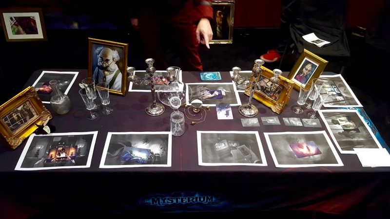 Les photos en noir et blanc avec les cartes protos en couleur sur la table : il faut trouver le mobile du crime.