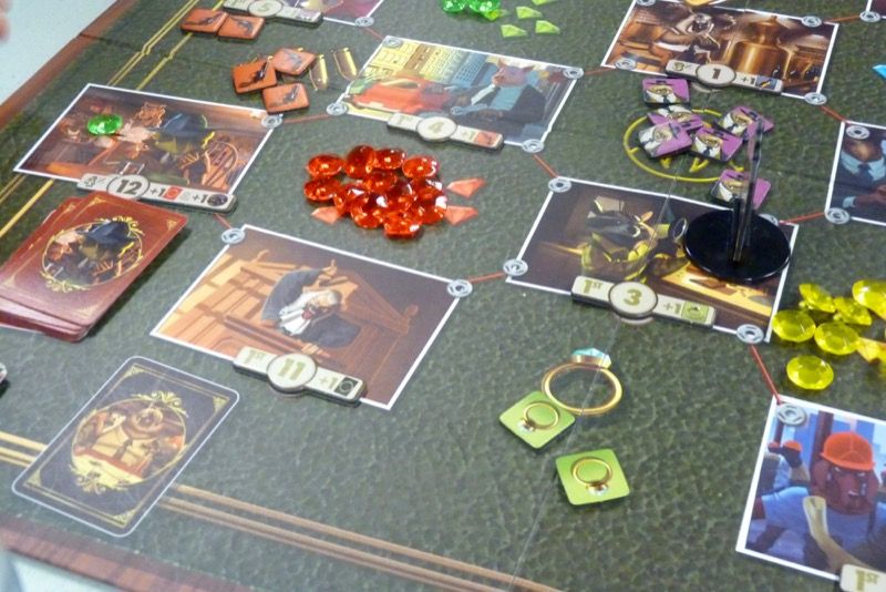 Une vue du plateau (une zone avec des personnages à influencer et une zone avec des bâtiments). Il n'y a plus de tuiles ni de cartes missions...