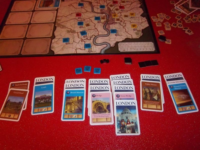 Les cartes de monsieur Fringe en fin de partie. Sur le plateau, les bâtiments bleus sont omniprésents. 