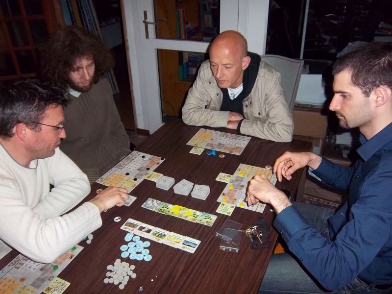 Monsieur Cormyr explique les règles de Peloponnes à messieurs Thomas, Rémi et Nicolas.