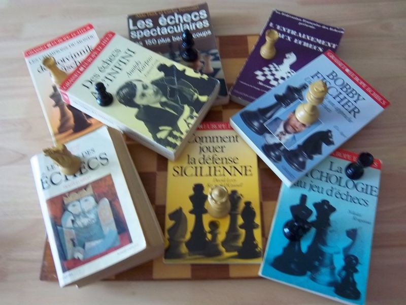 Quelques livres d'Echecs, parmi ceux qui reposent  sagement rangés dans ma bibliothèque. Dessous, mon tout premier échiquier...en bois.