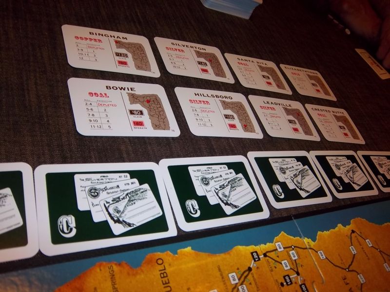 Les cartes : les mines en haut, les contrats en bas (Ils sont faces visibles quand le tour commence).