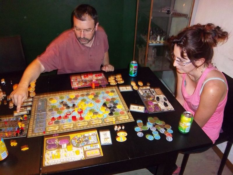 Monsieur Cormyr (en vacances donc mal rasé), sélectionne une tuile bonus sous le regard attentif de Mademoiselle A